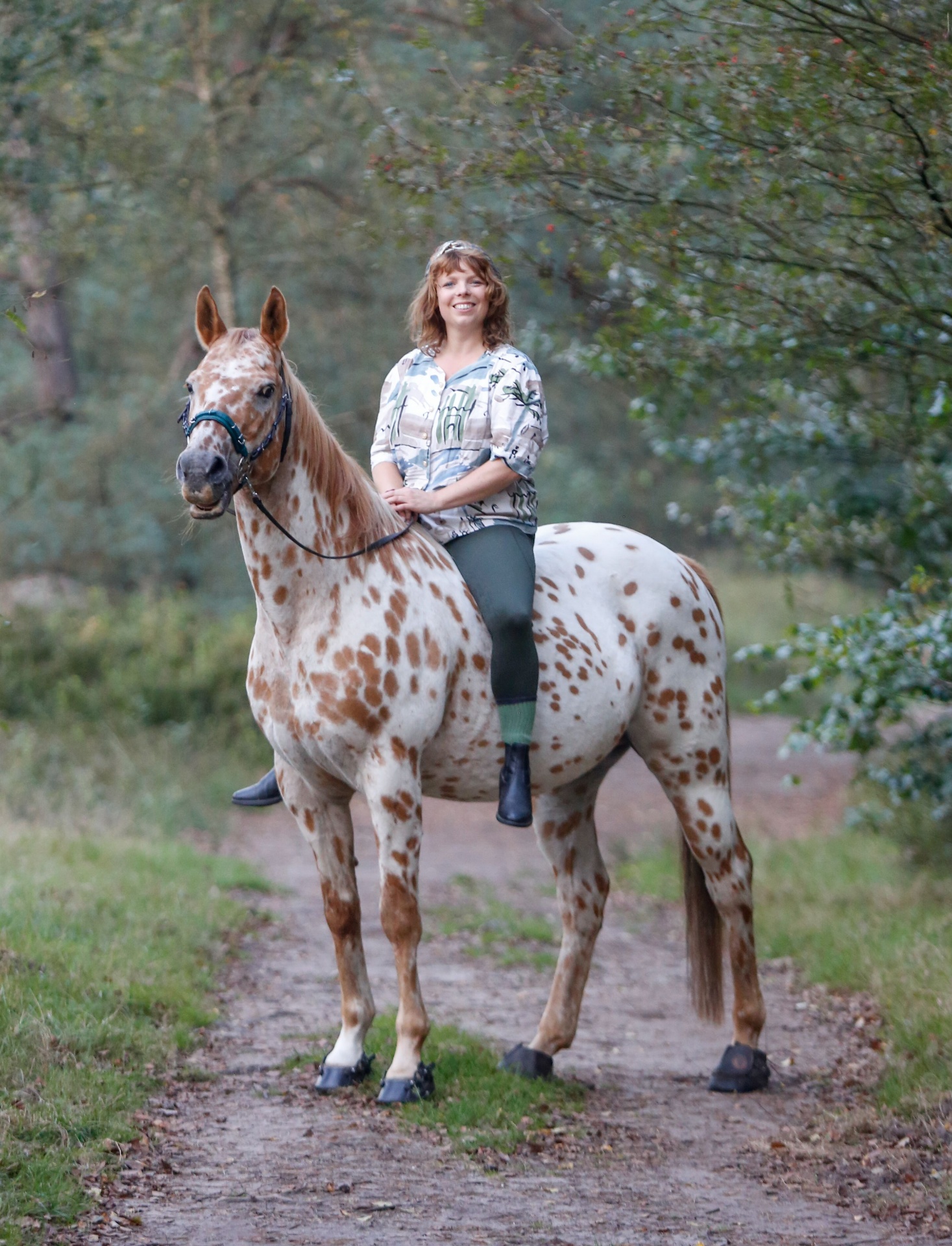 Shelley Meeuwsen op een appaloosa in het bos